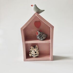 Huisje in roze met blauwe vogel