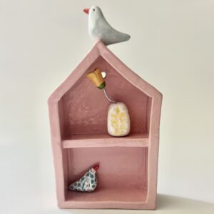 Huisje in roze met blauwe vogel